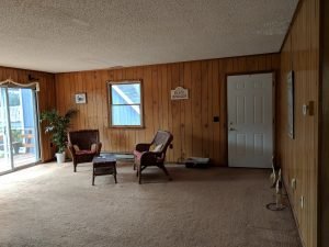 Completed living room with wood paneling and carpet