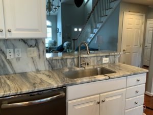 kitchen with granite countertop, backsplash, and breakfast bar